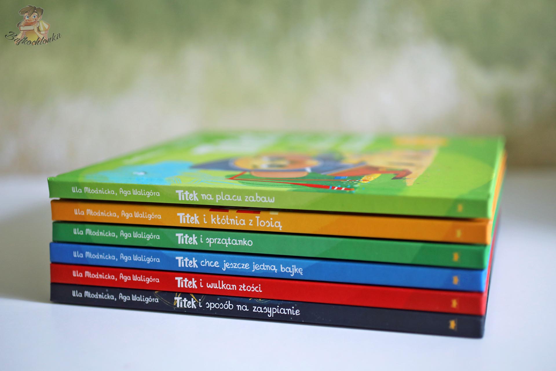 Grzbiety książek z serii Titek pokazujące tomy o placu zabaw, kłótni z Tosią, sprzątaniu, bajkach, złości i zasypianiu