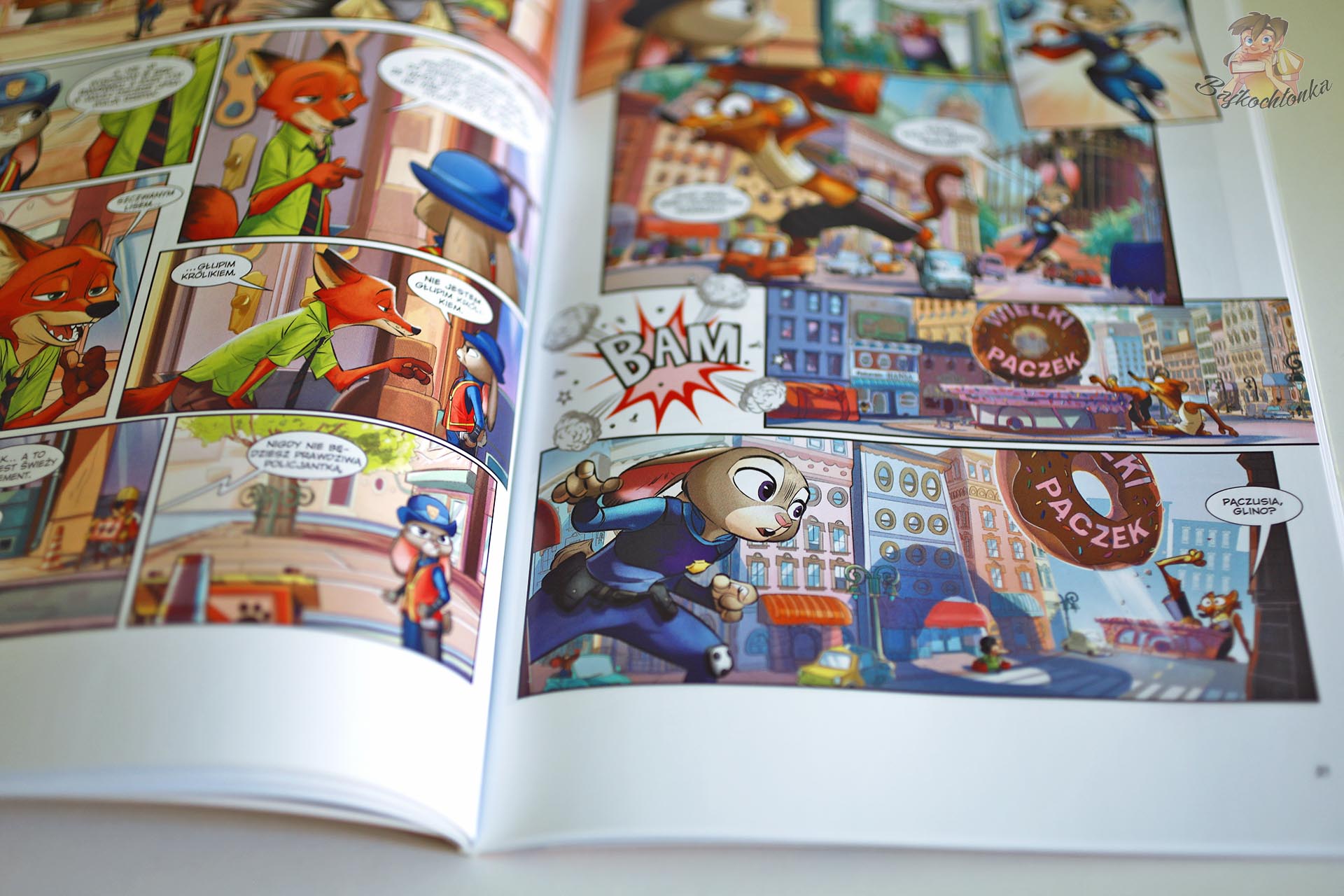Rozkładówka komiksu Zwierzogród z Judy Hops, Nickiem Bajerem i dynamiczną sceną pościgu w mieście