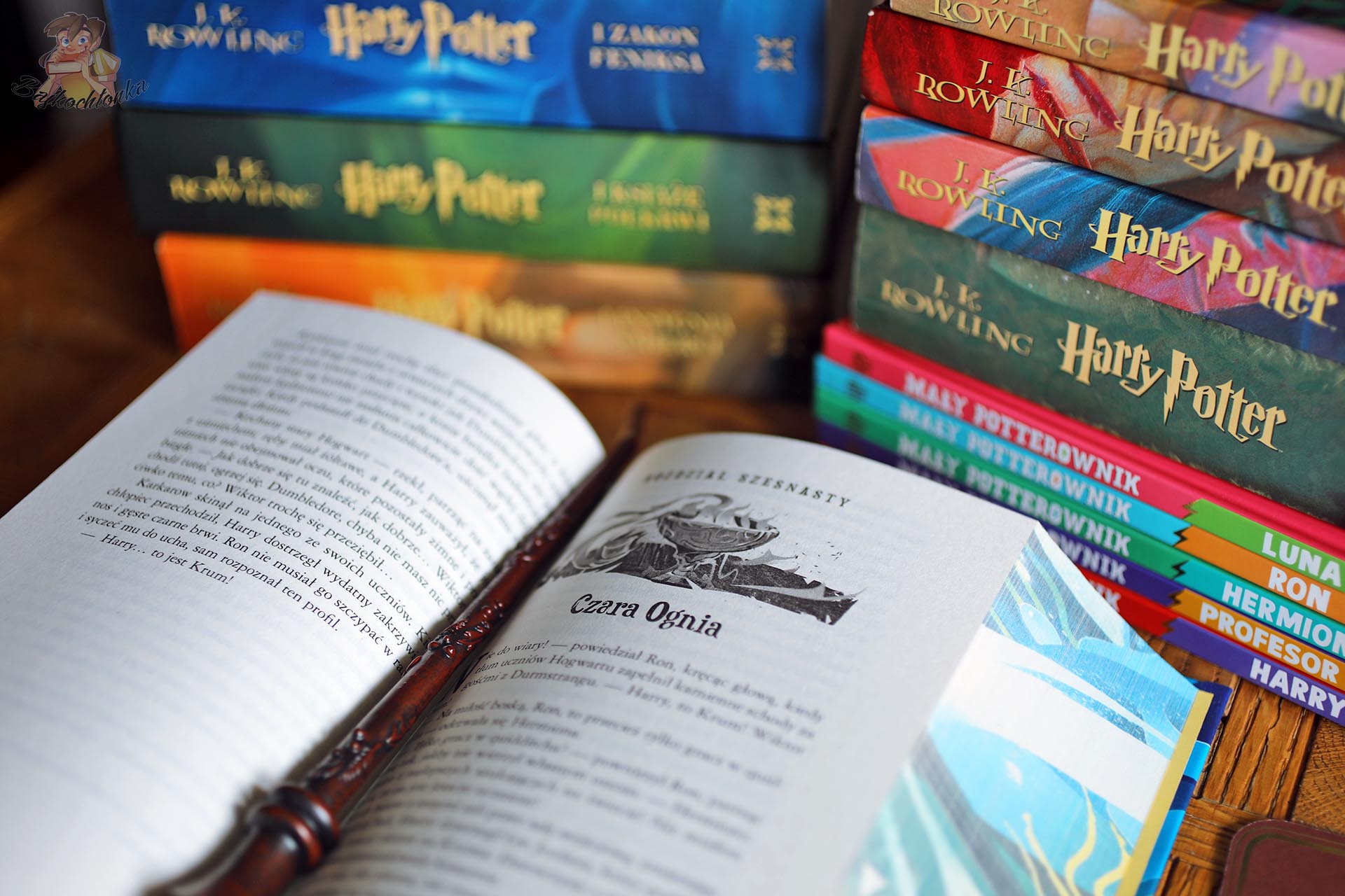 Otwarta książka Harry Potter i Czara Ognia z różdżką, barwionymi brzegami i kolekcją wydań w tle