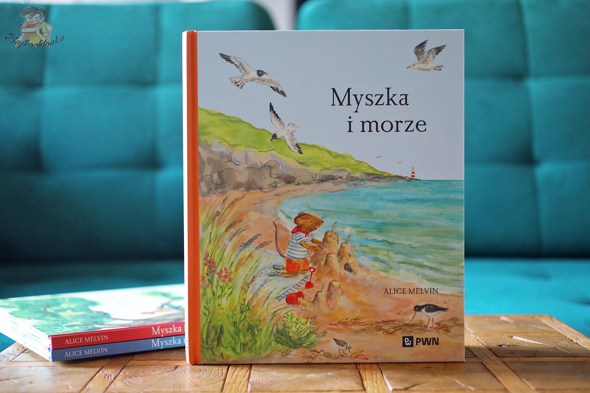 Okładka książki Myszka i morze Alice Melvin z Myszką budującą zamek z piasku