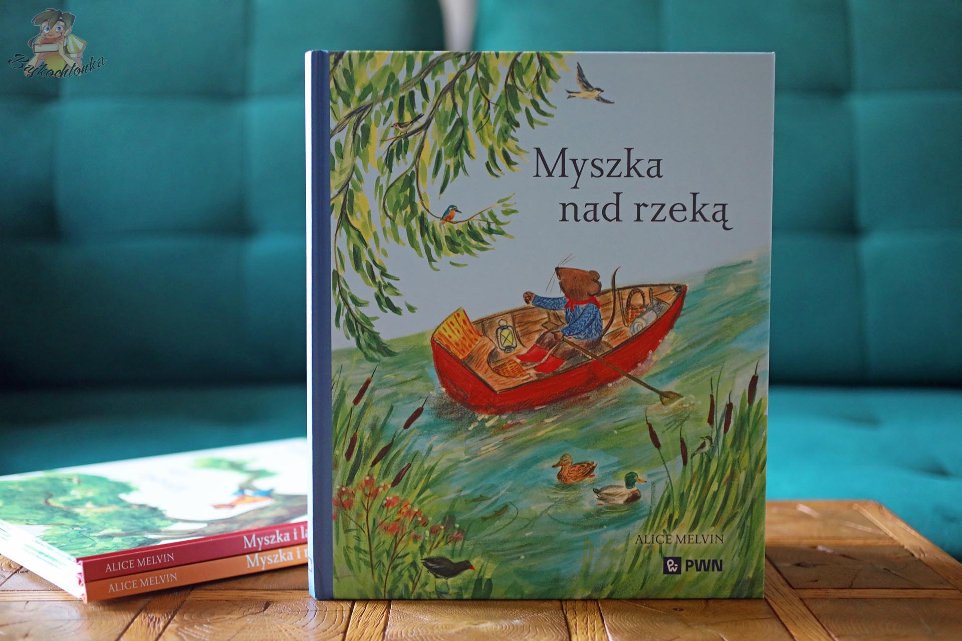 Okładka książki Myszka nad rzeką Alice Melvin z Myszką płynącą czerwoną łódką