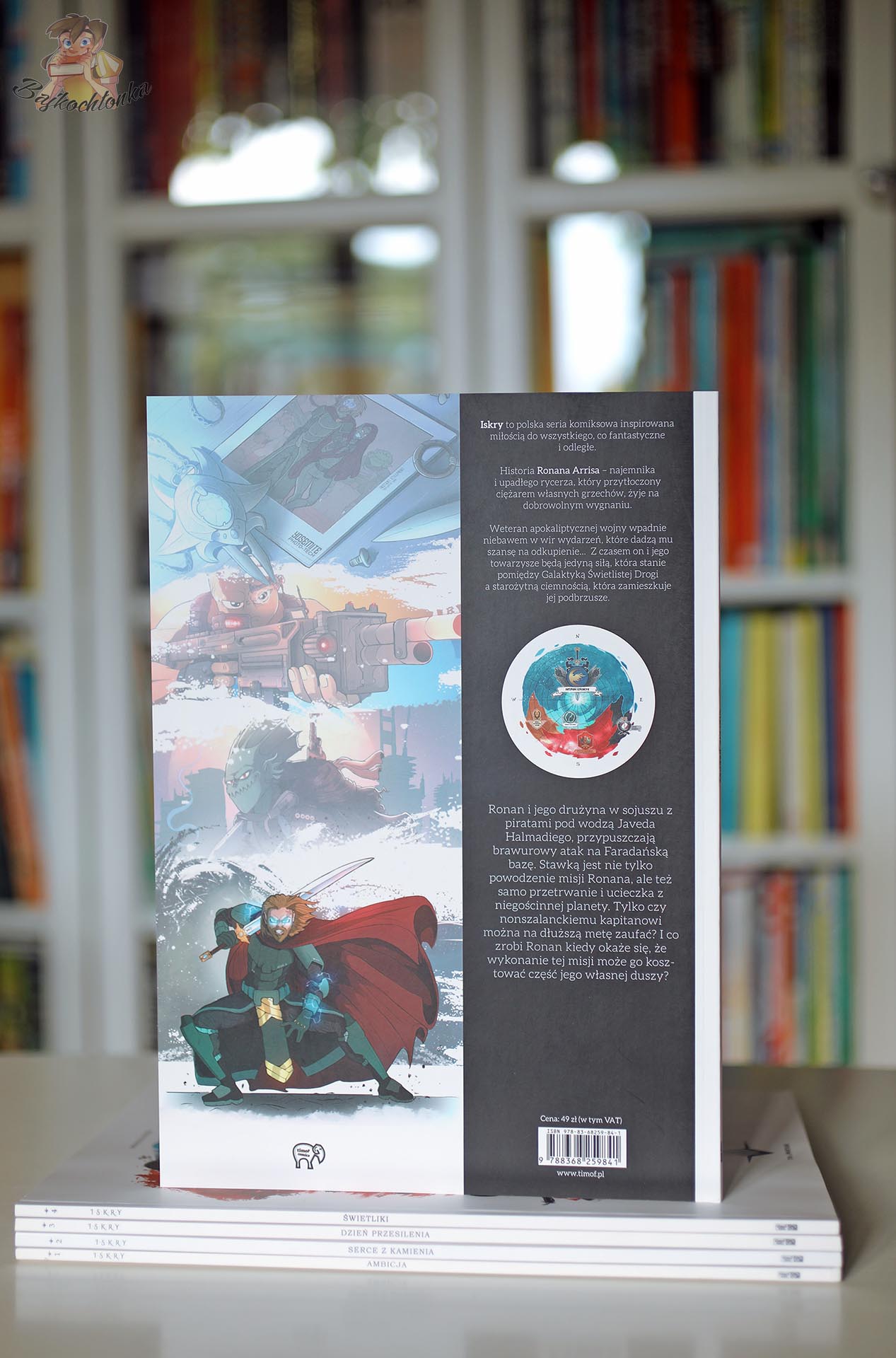 Tylna okładka komiksu Iskry. Tom 5. Wielkie rzeczy na tle domowej biblioteczki
