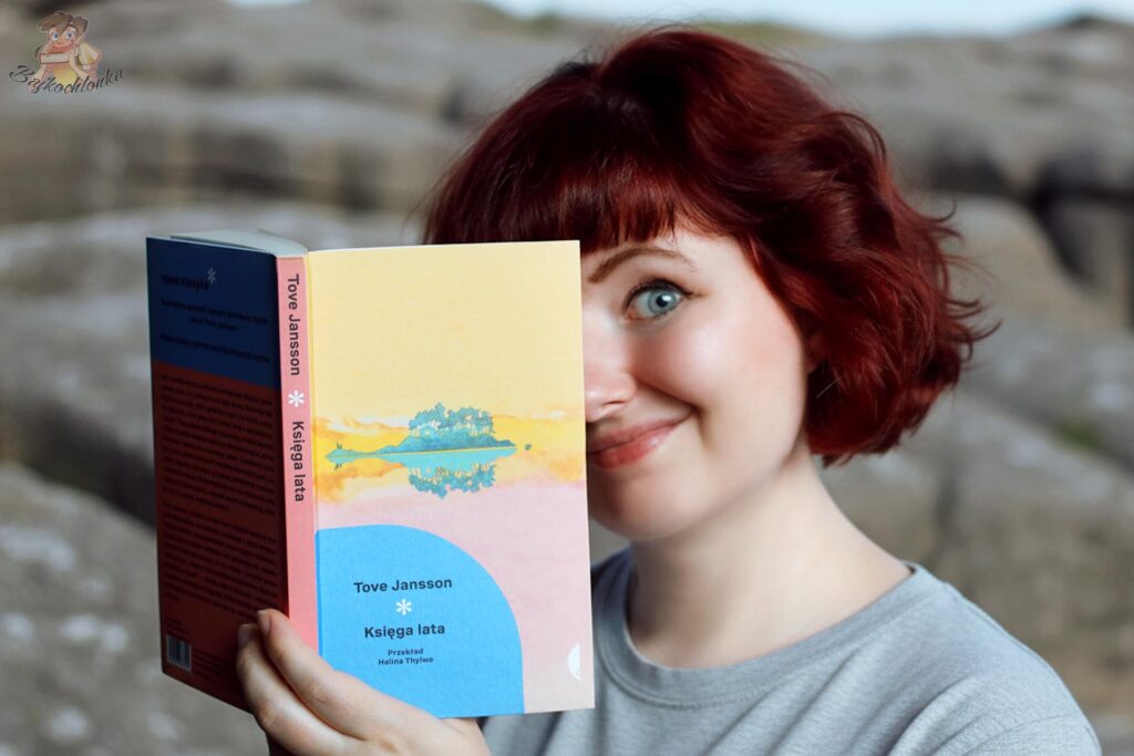 Czytelniczka z książką „Księga lata” Tove Jansson na tle skalistego krajobrazu