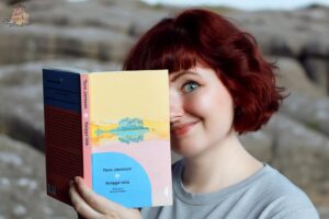 Czytelniczka z książką „Księga lata” Tove Jansson na tle skalistego krajobrazu