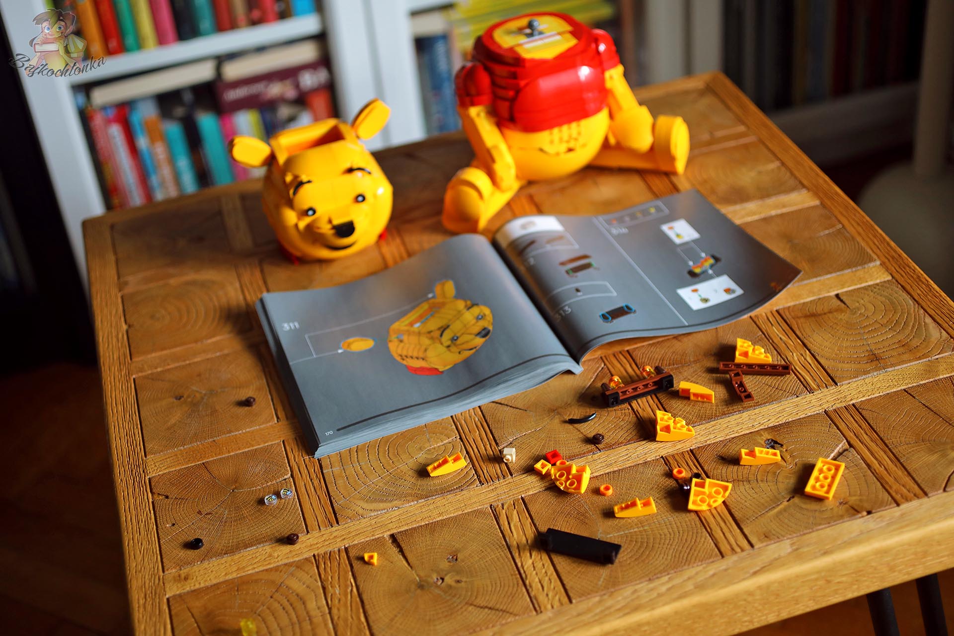 Rozłożone elementy, instrukcja i częściowo zbudowany Kubuś Puchatek z klocków LEGO®