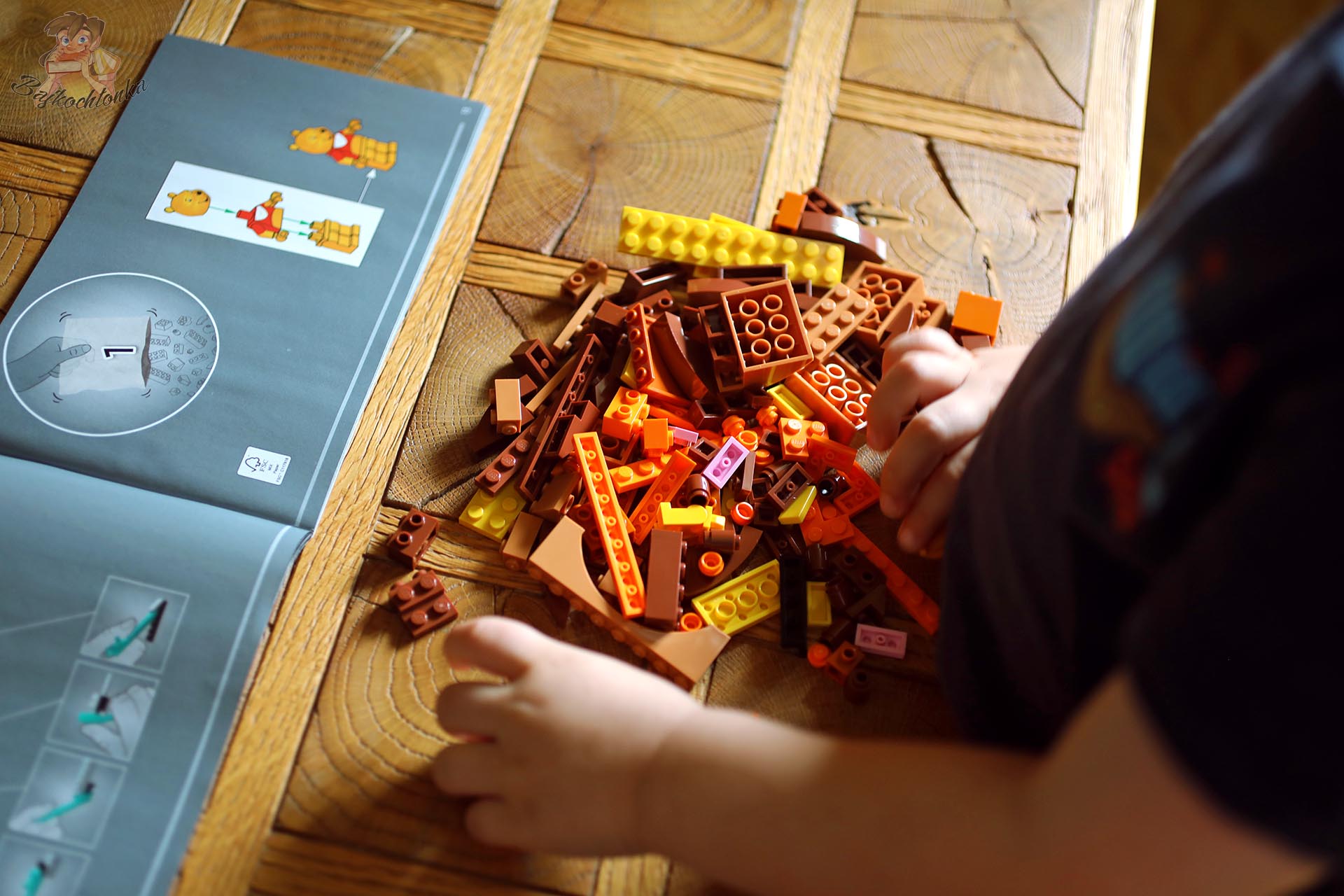 Dziecko składa zestaw LEGO® 43300 Kubuś Puchatek przy otwartej instrukcji