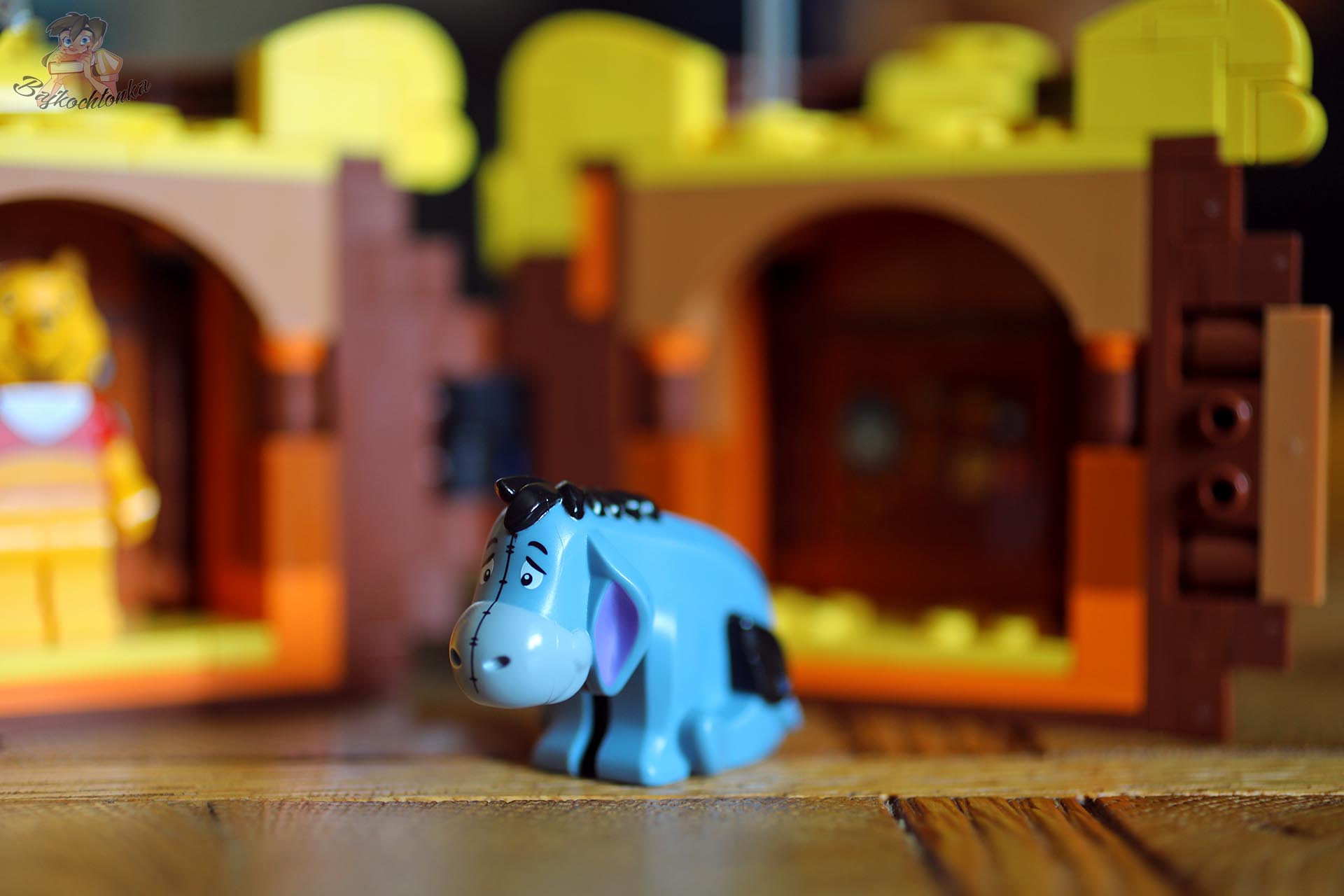 Figurka Kłapouchego z zestawu LEGO® 43300 na tle otwartego słoika z miodem