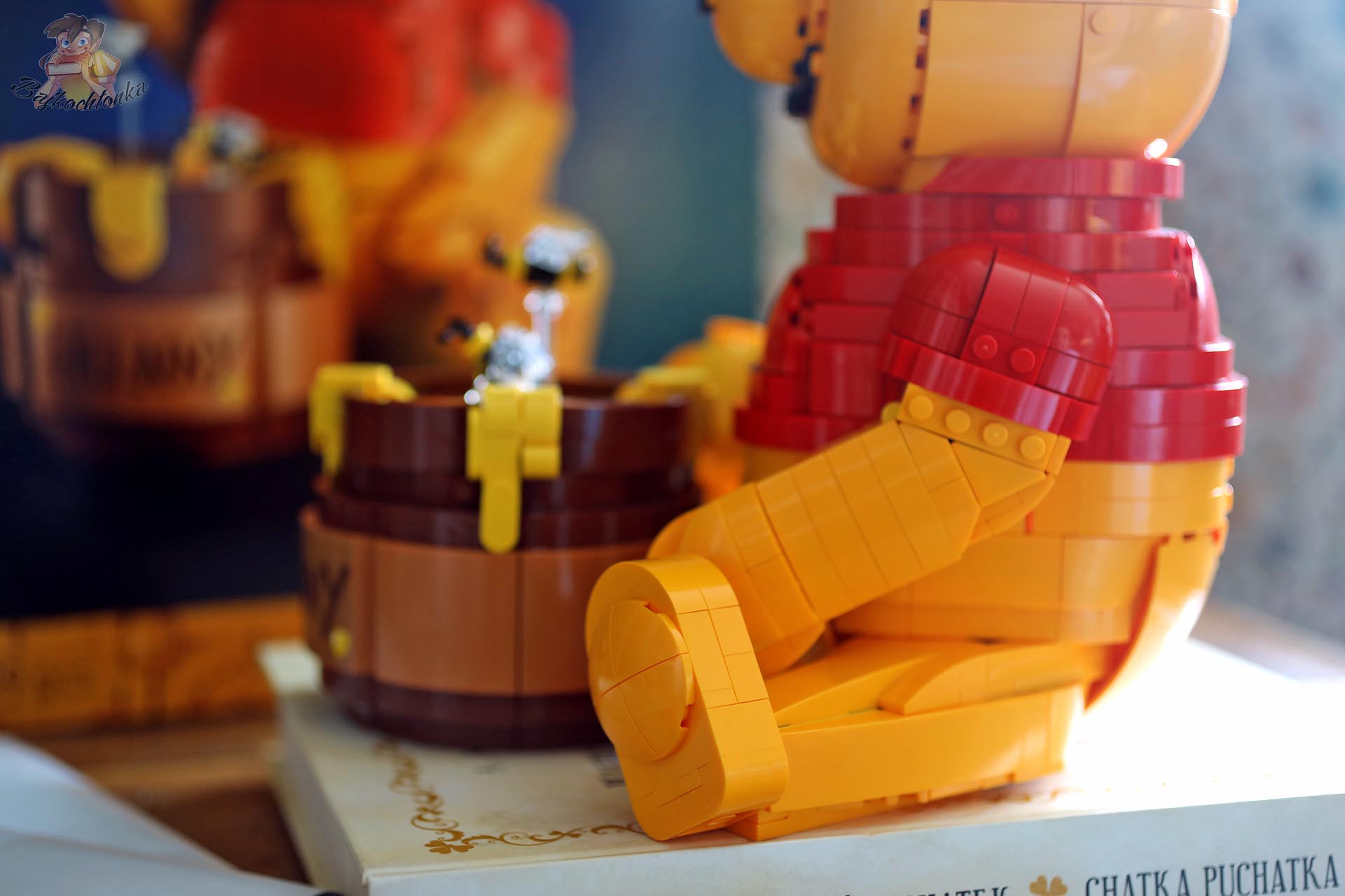 Boczne ujęcie figurki LEGO® Kubuś Puchatek z ruchomym ramieniem i słoikiem miodu