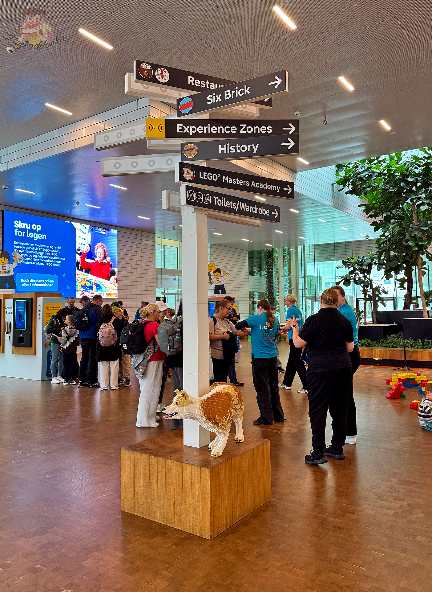 Wnętrze LEGO House z drogowskazami do Experience Zones, History i LEGO Masters Academy