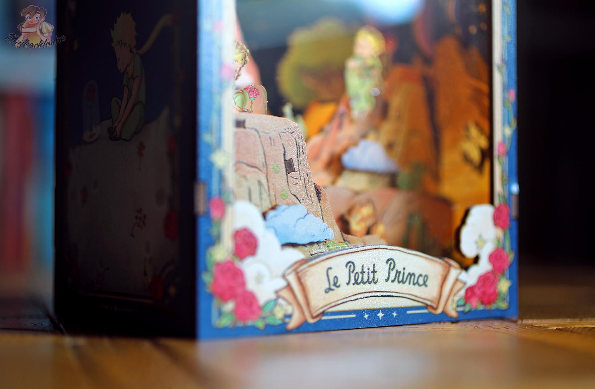 Detal frontu book nooka Le Petit Prince z przestrzennym krajobrazem i figurkami