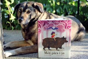 Książka Mój pies i ja Luki Tortoliniego i Felicity Sali sfotografowana obok psa