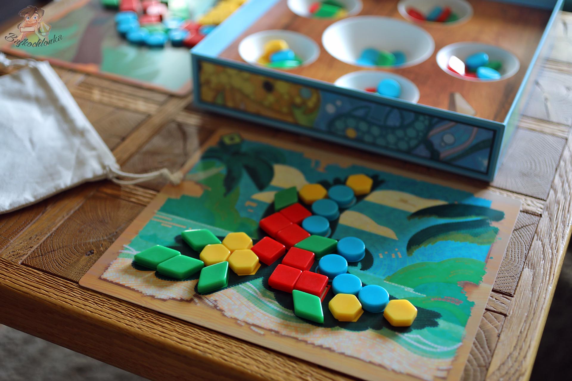 Rozgrywka w Azul Kids z planszetką, kolorowymi kafelkami i podajnikiem