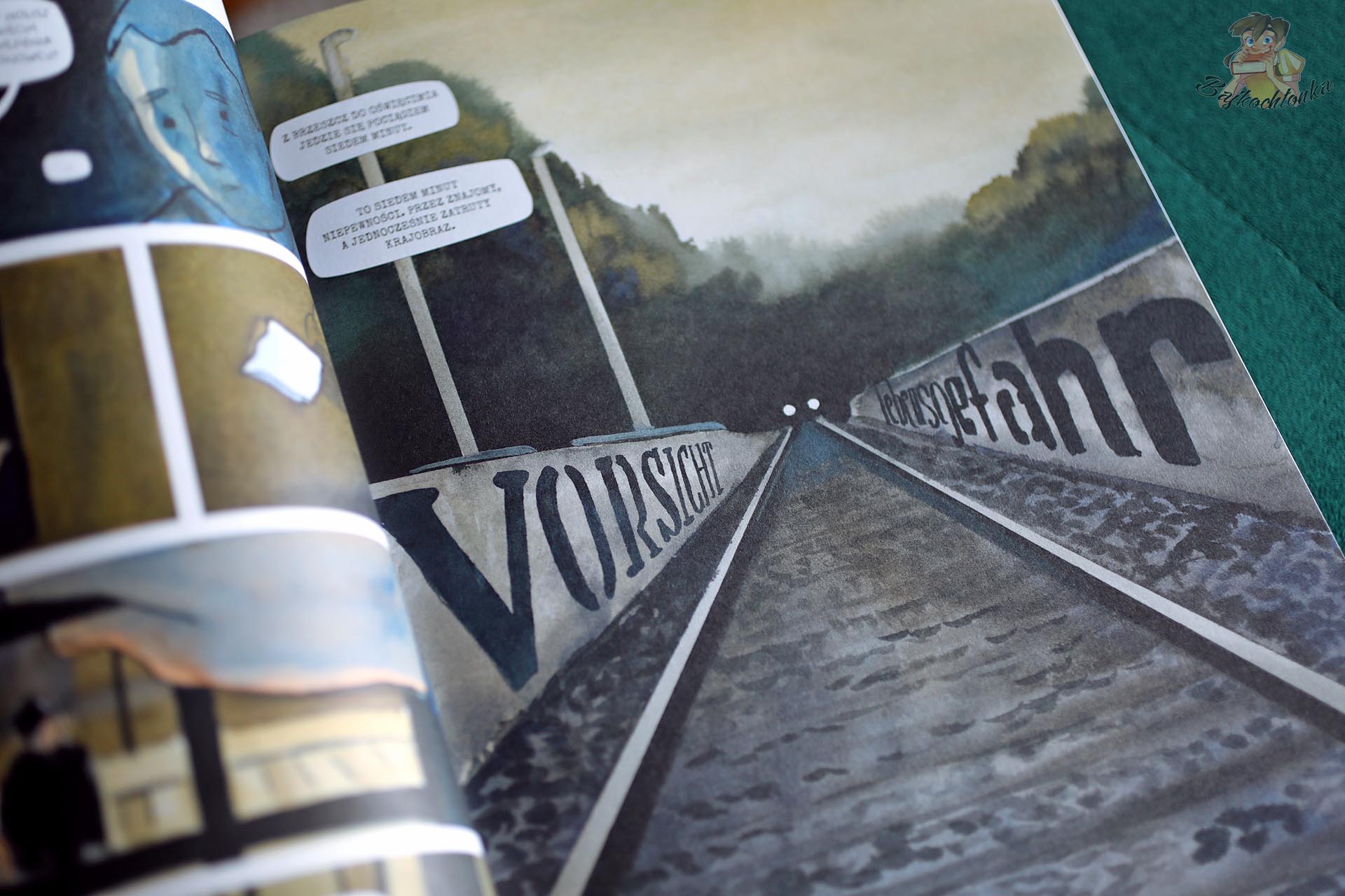 Ilustracja torów kolejowych z niemieckimi napisami w komiksie Czy tutaj śpiewają ptaki? o historii Auschwitz