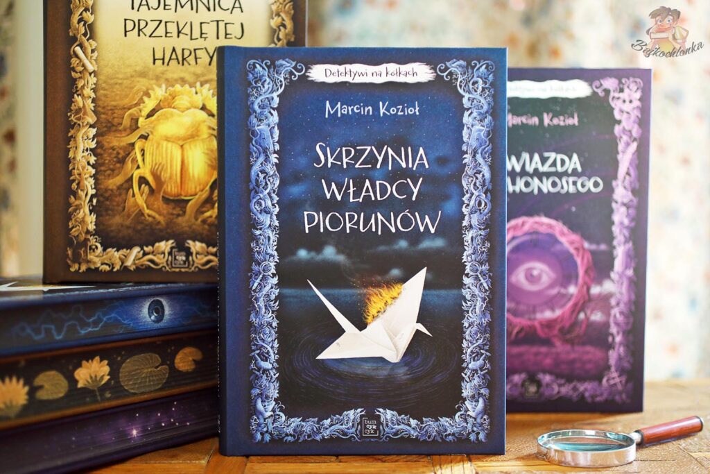 Skrzynia Władcy Piorunów Marcina Kozioła – nowe wydanie z okładką Marcina Minora, na tle pozostałych tomów serii Detektywi na kółkach.