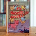 Okładka książki Kto zabił naszego koguta? Andersa Sparringa i Pera Gustavssona z różową lisicą, kurami i martwym kogutem.