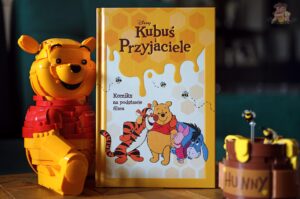 Kubuś i przyjaciele – komiks na podstawie filmu Disneya obok figurki LEGO Kubusia Puchatka