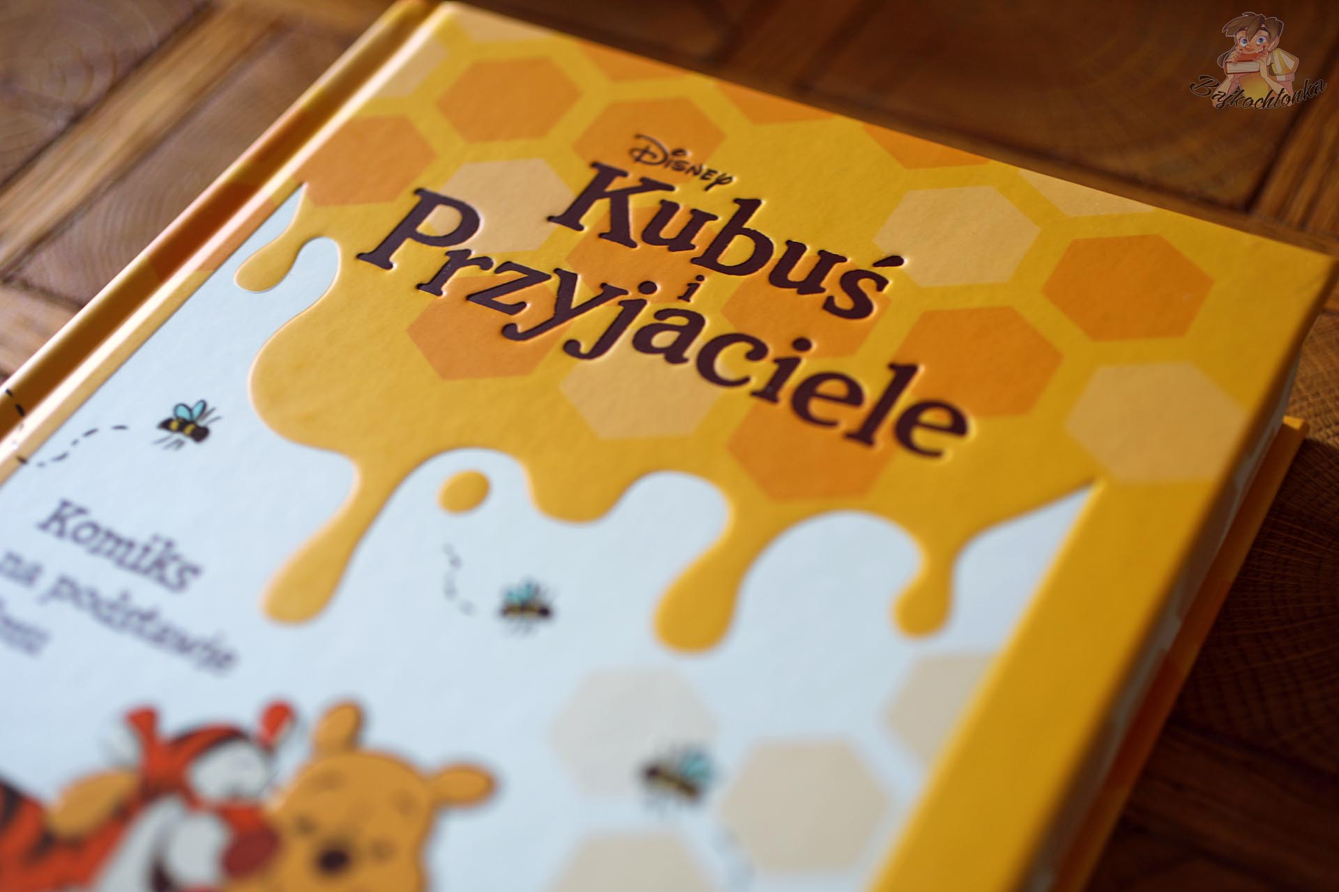 Okładka komiksu Disneya Kubuś i przyjaciele z motywem miodu i plastra miodu