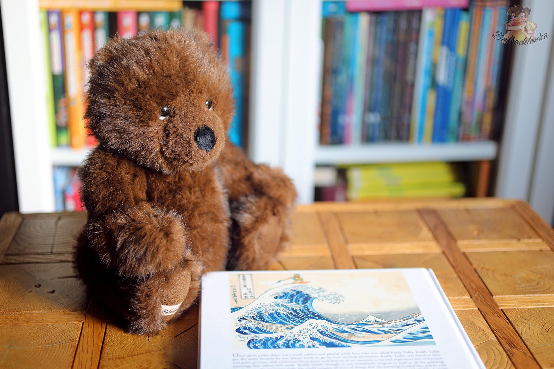 Brązowy miś Bukowski Design obok książki Teddy Bears on an Adventure in World Art z ilustracją inspirowaną Wielką falą w Kanagawie.