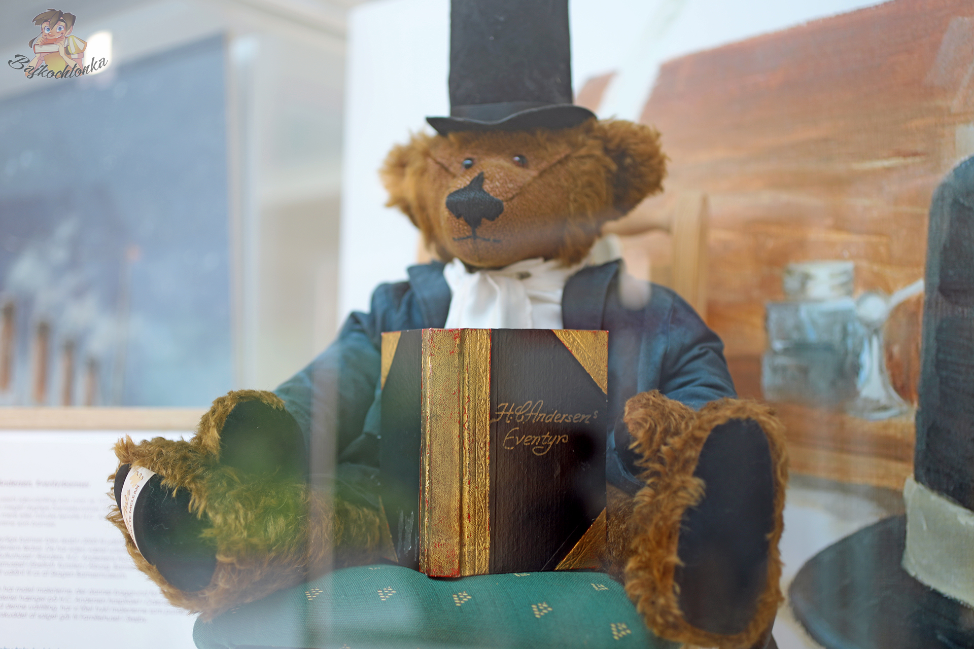Pluszowy miś w stroju Hansa Christiana Andersena z książką baśni, prezentowany w Teddy Bear Art Museum.